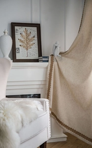 Détail d'un rideau en lin beige clair avec des bordures brodées vintage marron foncé