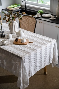 Detailed view of white vintage tablecloth with 3D wave pleats and hollow lace edges