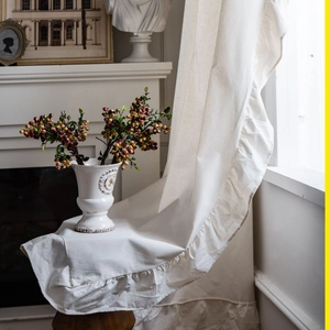 French style creamy white cotton linen curtain with ruffled edges in a warm home setting