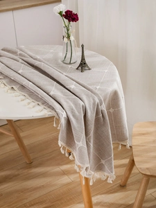 Detailed view of linen blend tablecloth with white diamond embroidery and fringe trim