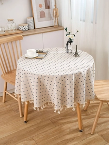 Detailed view of round cotton linen tablecloth with floral pattern and cotton fringe edge