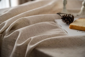 Close-up of oatmeal linen tablecloth showing natural woven texture and soft folds