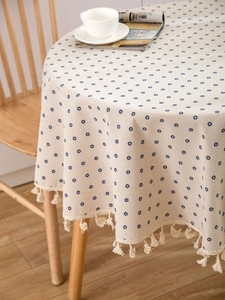 Detailed view of round cotton linen tablecloth featuring blue floral patterns and tassels