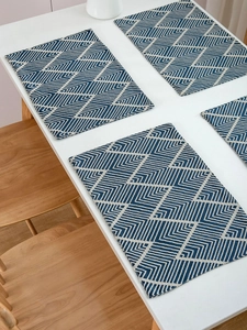 Detailed view of navy blue geometric herringbone pattern placemats on a dining table