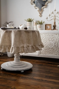 Close-up of beige linen round tablecloth with elegant ruffled edges for home decor