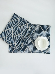 Detail of navy blue wavy textured table mat with geometric jacquard weave and tea cup