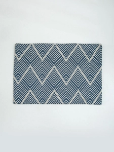 Close-up of navy blue and beige woven placemat featuring a geometric zigzag pattern
