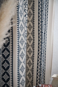 Detail of bohemian blue floral pattern on beige cotton linen curtain fabric texture