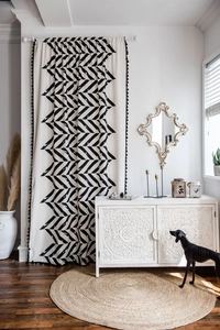Detail of bohemian cotton linen curtain with black geometric pattern and tassel trim