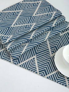 Macro shot of navy blue zigzag woven placemat showing thick fabric texture and edge stitching