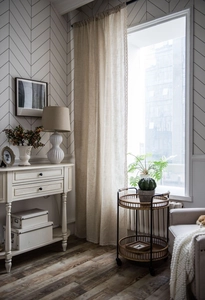 Detail view of beige linen curtain showing semi-sheer texture in a modern interior setting
