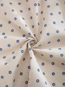 Detailed macro view of the linen texture and blue floral print on the round tablecloth
