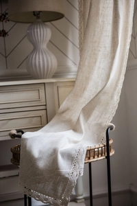 Detailed texture of beige linen curtain featuring elegant scalloped crochet lace edges