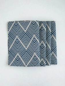 Close-up of navy blue and beige zigzag jacquard placemats in a thick linen texture set