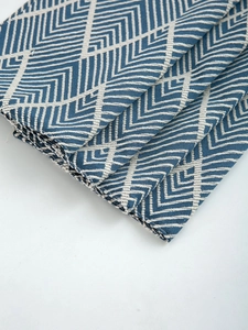 Detailed close-up showing navy blue wavy jacquard texture and thick fabric of the table mat