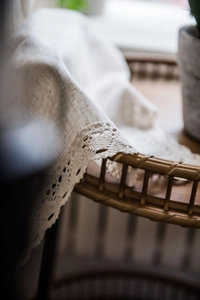 Detail of beige linen fabric with intricate crochet lace trim and rustic textures