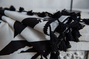 Close-up of black and white geometric print curtain with detailed handmade tassels