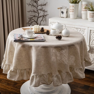 Linen round tablecloth with ruffle edge design on a table in a warm cozy setting
