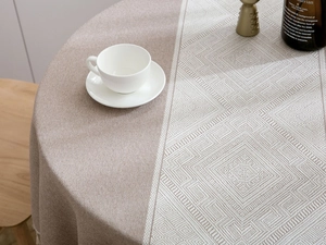 Close-up of modern round tablecloth featuring green jacquard textures and geometric patterns