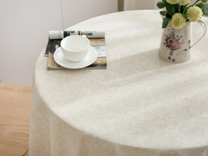 Close-up detail of beige polyester-linen tablecloth showing twill texture and tassels