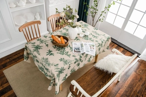 Close-up of pine needle print on beige linen tablecloth with rustic fabric texture
