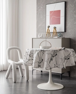 Detailed view of round marble print tablecloth with high-quality draping in a modern room