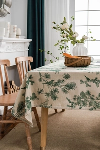 Detailed macro shot of pine needles and bird print on vintage linen tablecloth