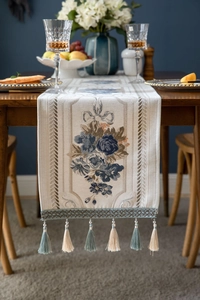 Detail of jacquard table runner with rose embroidery and beaded fringe tassels