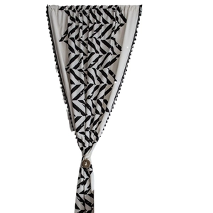 Minimalist black and white geometric pattern curtain with decorative ball tassels and deer tieback