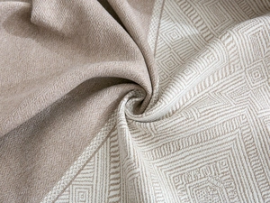 Close-up of premium green and beige jacquard fabric with geometric patterns