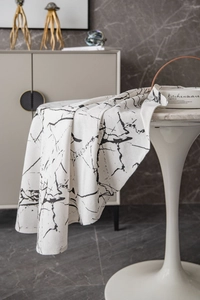 Detail of minimalist marble print tablecloth showing the textured fabric and draped edge