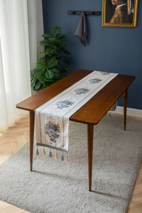 Close-up of European jacquard table runner with blue floral patterns and tassels