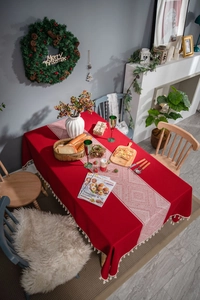Détail de nappe de fête rouge avec chemin de table géométrique et pompons élégants