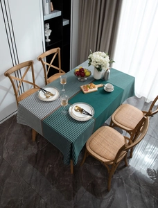 Detailed top view of dark green houndstooth and striped tablecloth on a dining table
