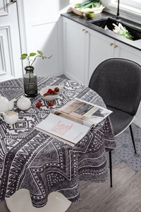 Close-up of bohemian round tablecloth with gray geometric patterns in a cozy dining setting
