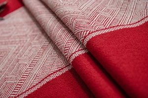 Vue macro détaillée du motif jacquard à losanges tissé sur une nappe de fête rouge