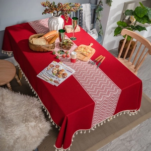 Red festive tablecloth set with wavy pattern runner and white fringe tassels decoration