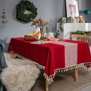 Red festive tablecloth with white V-pattern stripe and decorative fringe tassels