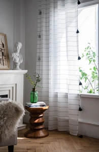 Macro detail of semi-sheer white striped curtain with elegant black tassel fringe trim