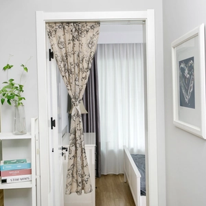 Moderner Türvorhang mit schwarzem Blumenmuster auf beigem Stoff in heller Wohnumgebung