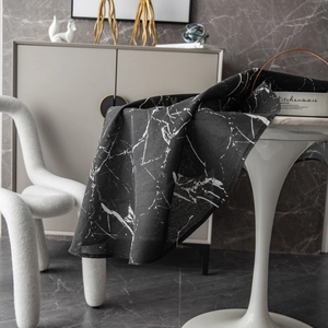 Modern black marble print round tablecloth draped on a dining table in a minimalist interior