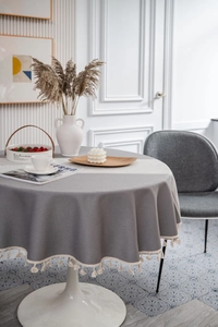 Macro detail of grey jacquard tablecloth with elegant woven texture and beige fringe tassels