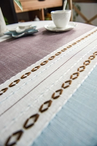 Detailansicht der Tischdecke aus Baumwolle mit geometrischer Stickerei und Spleißdesign