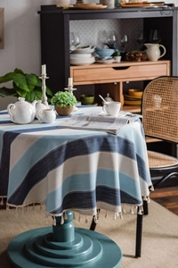 Detailed view of blue and white striped cotton linen tablecloth with fringe tassels