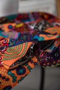Macro detail of Bohemian colorful printed fabric showing fine stitching on sleeve cuff