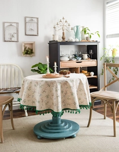 Detail showing the floral pattern cotton linen tablecloth with green tassel edges