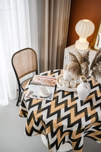 Top view of round tablecloth with black yellow and white wave patterns in cozy home setting