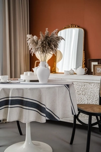 Detail of round cotton linen tablecloth with navy stripes in a minimalist home setting