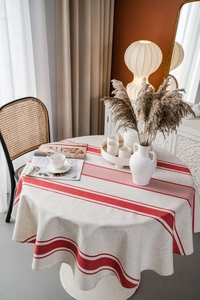 Detail einer runden Tischdecke aus Baumwollleinen mit roten Streifen im Wohnambiente