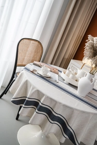 Detailed close-up of a navy blue striped cotton linen round tablecloth in a home setting